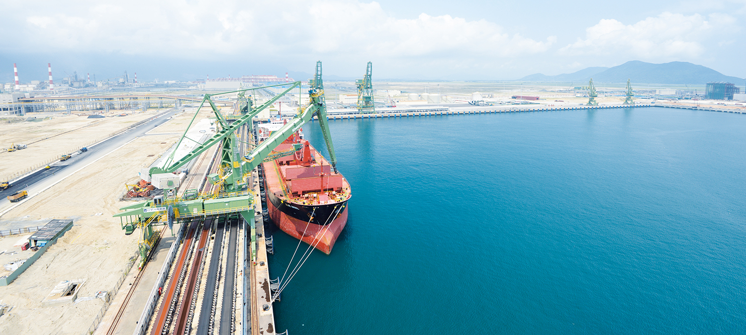 Green Siwertell shipunloader in operation unloading coal from ship in Vietnam birdseyeview