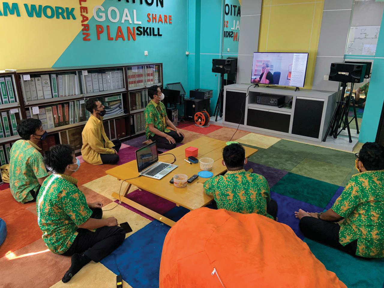 People sitting on the flooring participating in Bruks Siwertell training