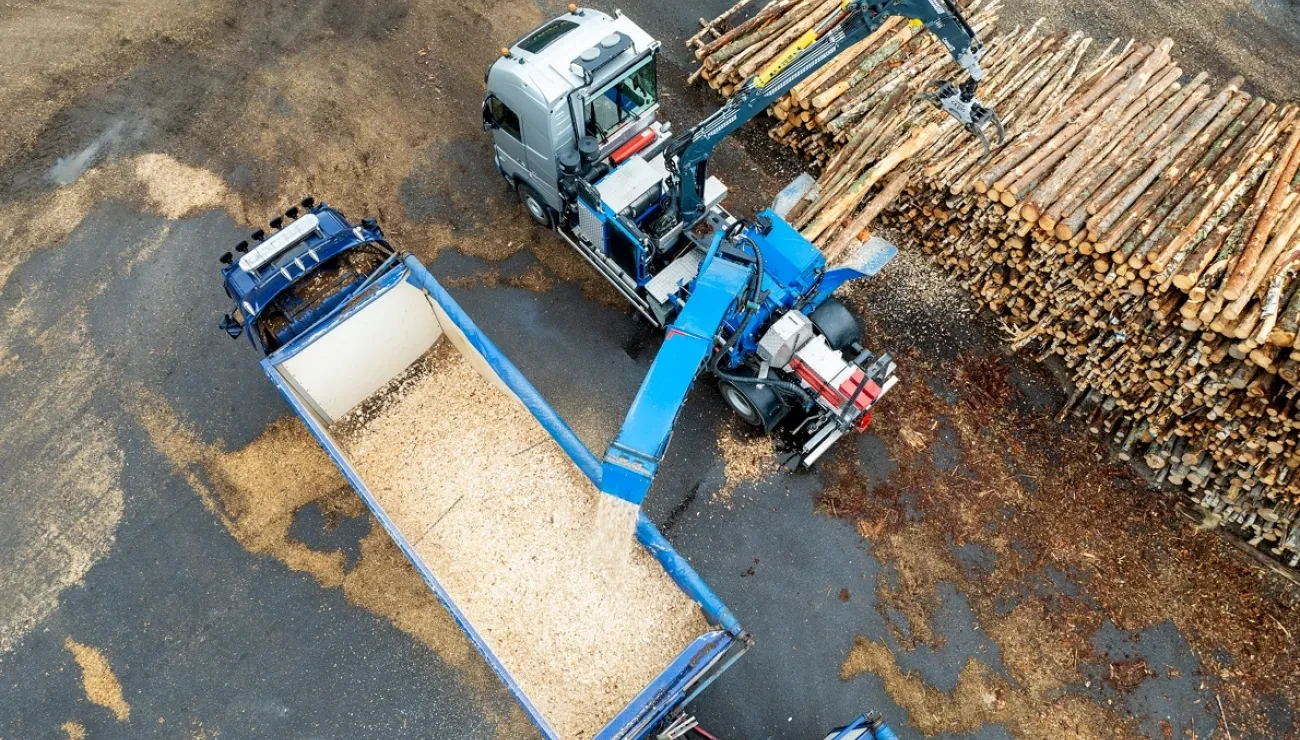 mobile chipper, wood logs and truck from drone view