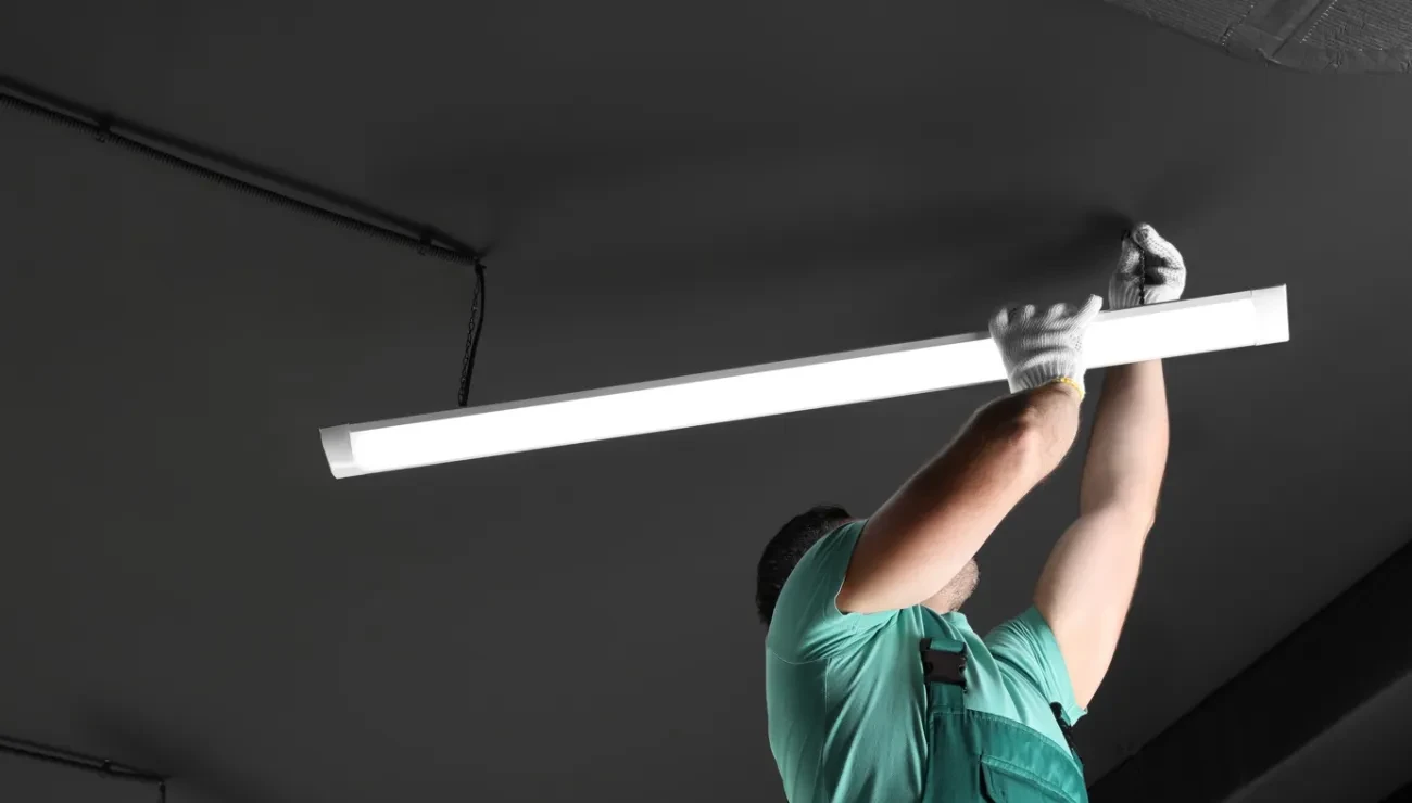 man installing lights in ceiling