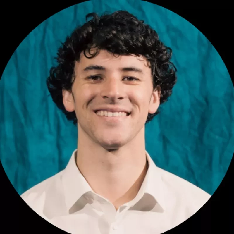 portrait of man in front of blue curtain
