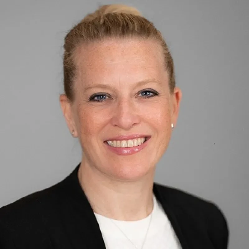 Portrait of woman in blazer with gray background
