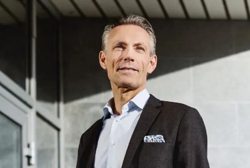 Man in shirt and blazer standing in sunshine