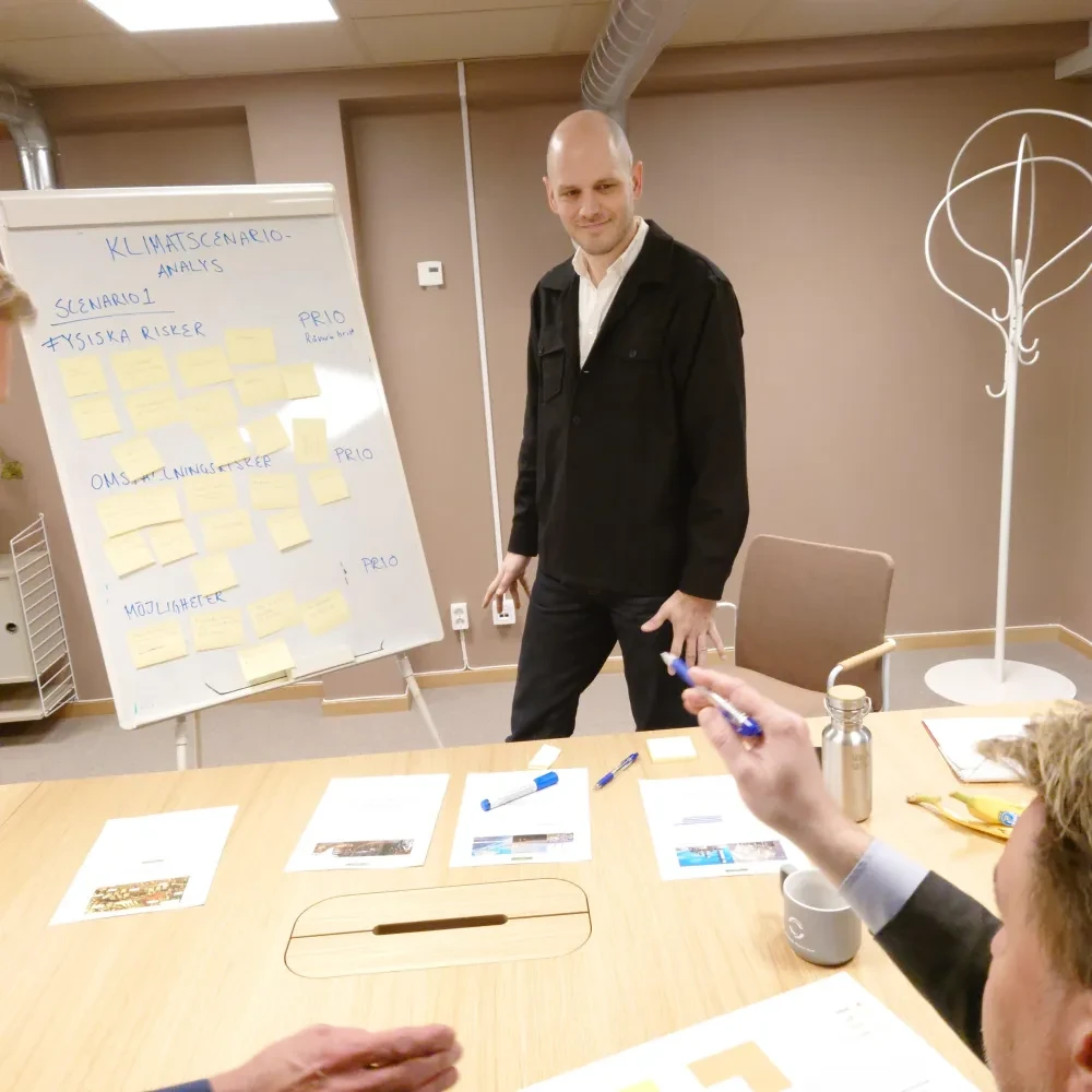 Workshop with person presenting on board iwth postits