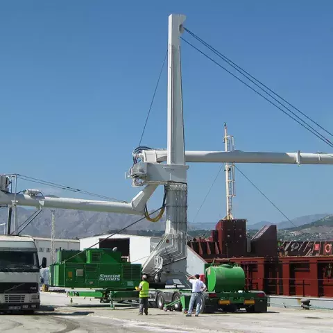 Road-mobile unloader in operation, unloading from ship to two trucks