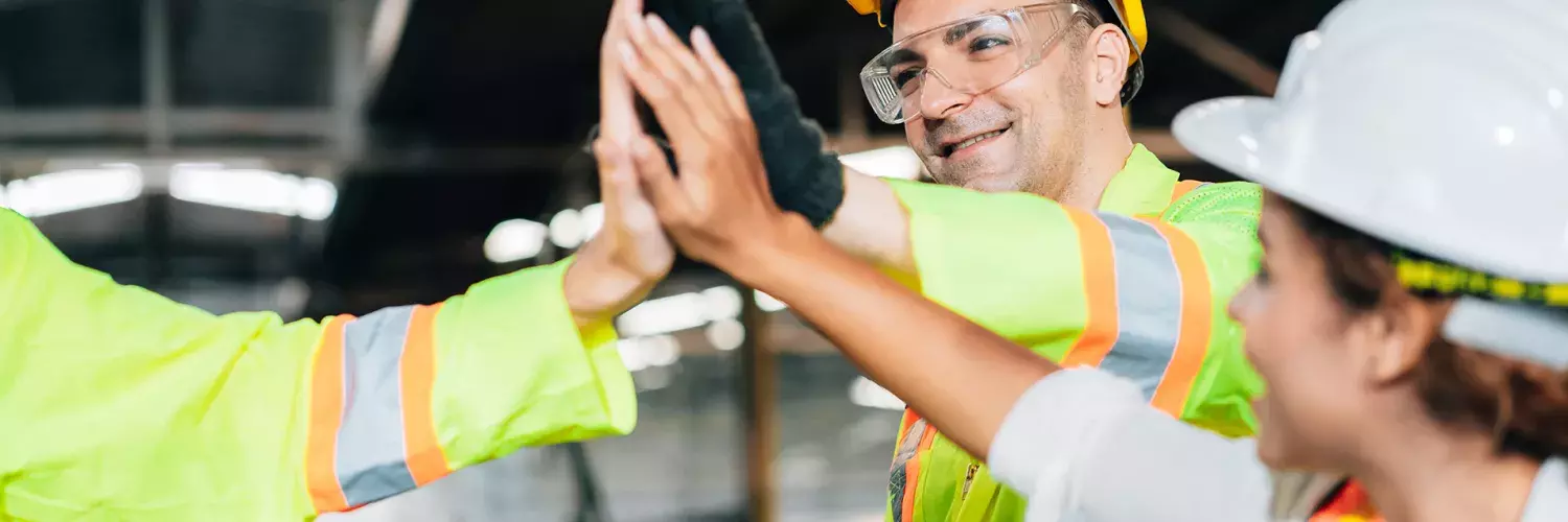 Workers with helmets doing high five