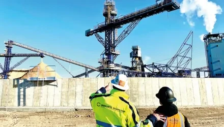 Two men with hardhats looking at stacker reclaimer