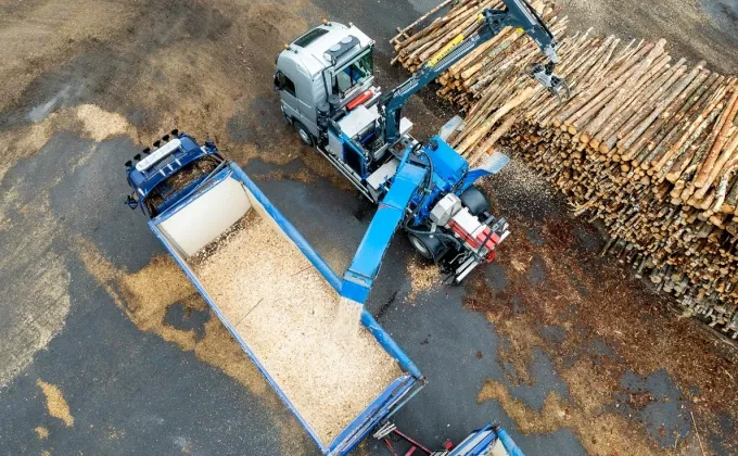 mobile chipper, wood logs and truck from drone view