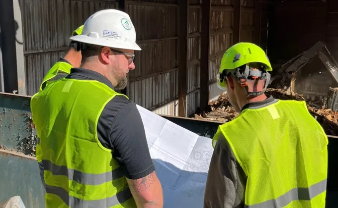 two persons in high visibility vests and hardhats