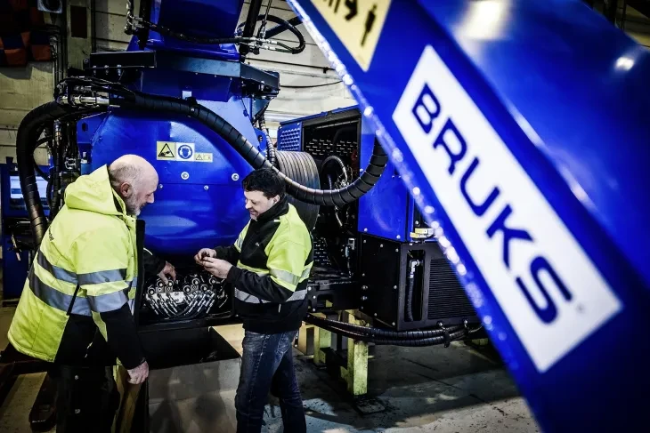 two men repairing a machine