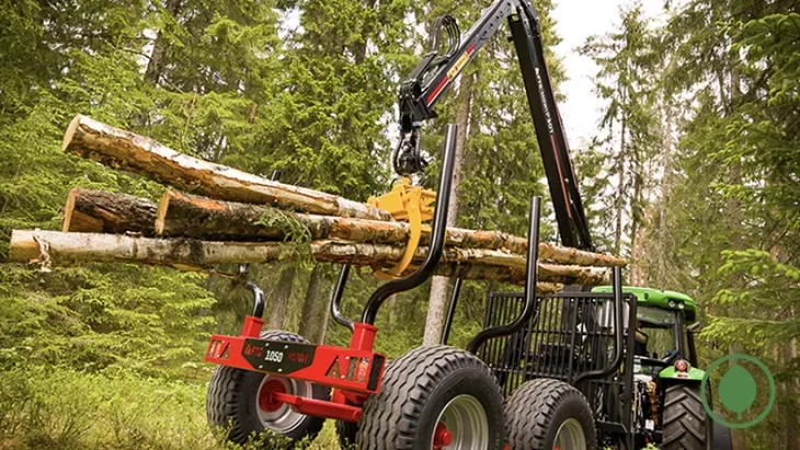 crane lifting logs in forest